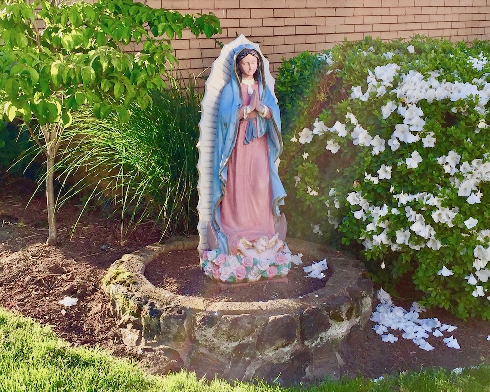 statue of Mary in front garden of brick house
