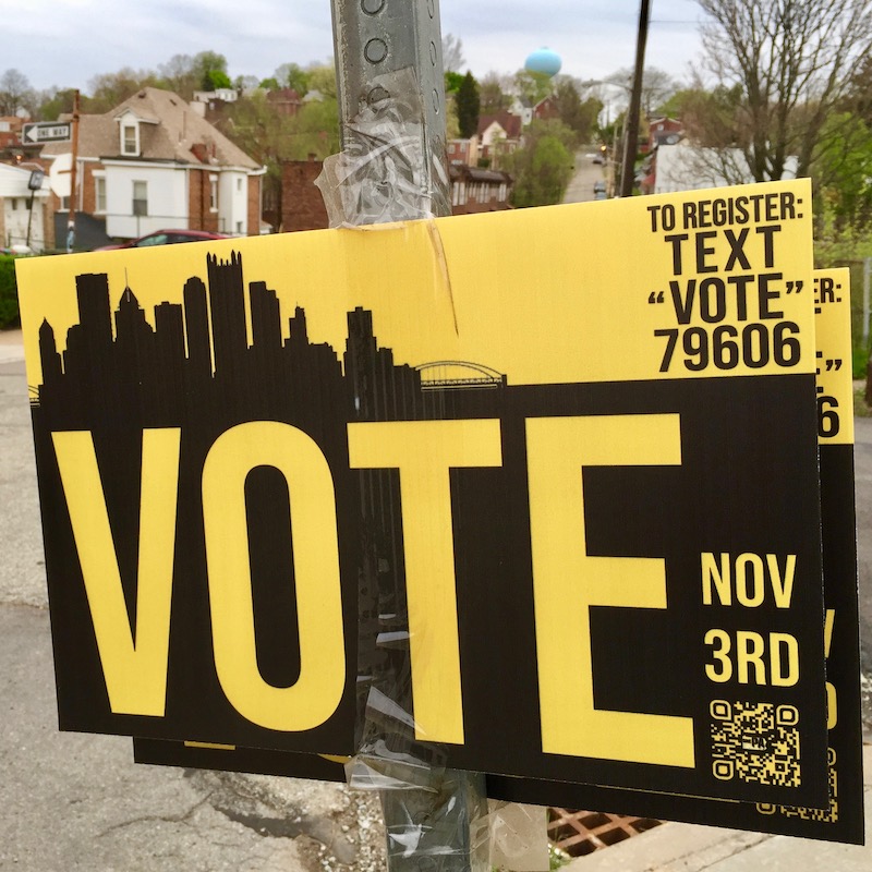pro-vote sign taped to street sign
