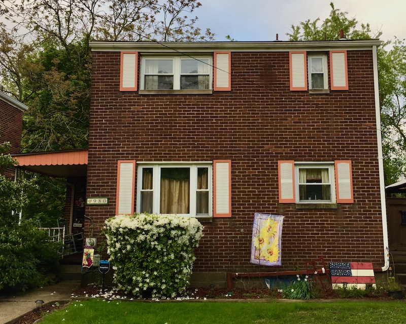 shipping pallet painted like the American flag in front of brick house