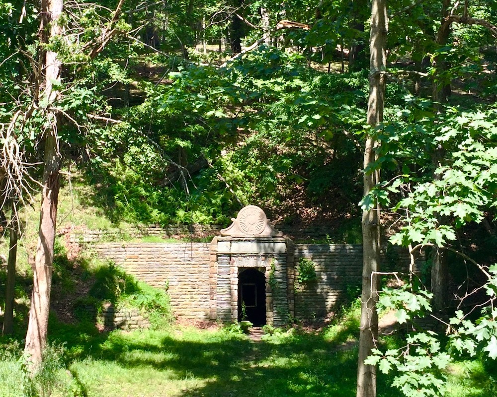 stone spring house embedded in wooded hillside