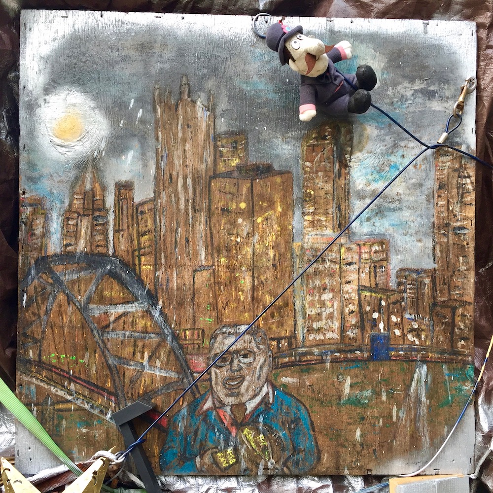 painting of downtown Pittsburgh skyline on wood panel on front porch of small house