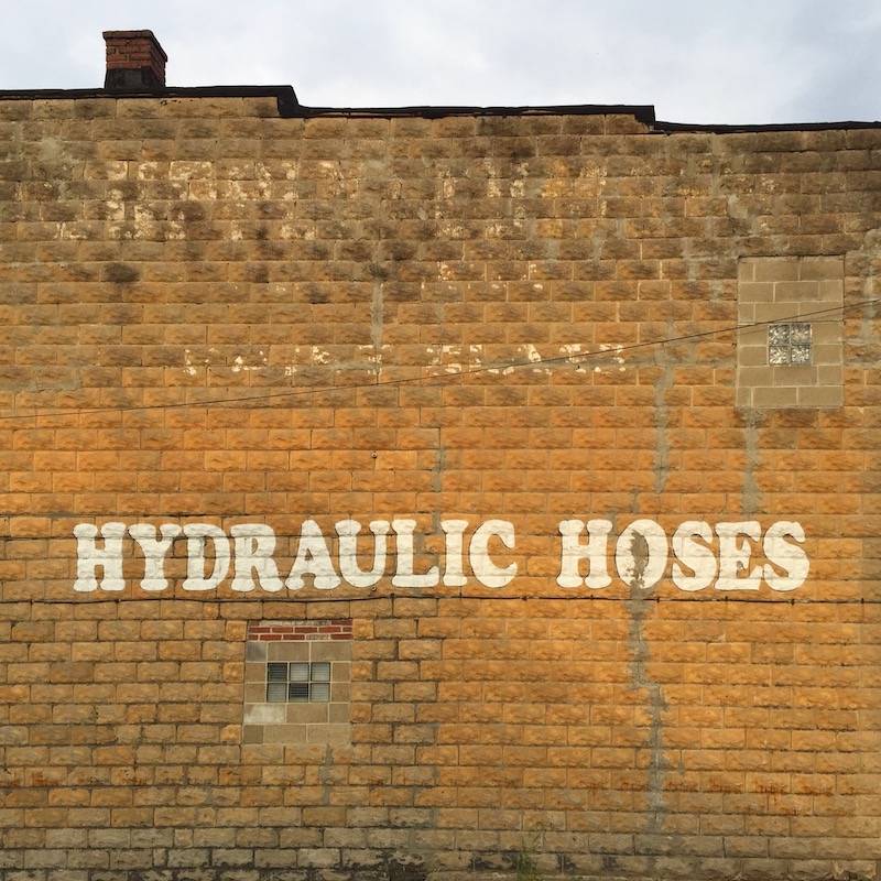 "Hydraulic Hoses" sign painted on masonry walllll