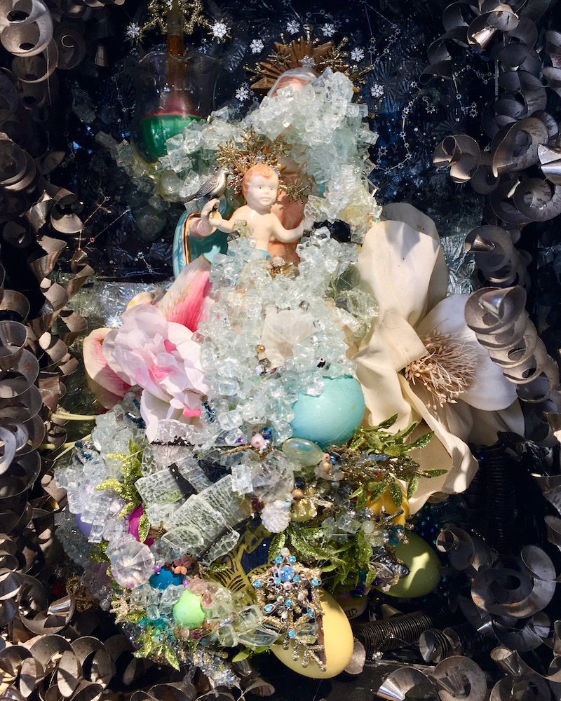 assemblage artwork by Glendon Hyde of small baby in fantasy bedding