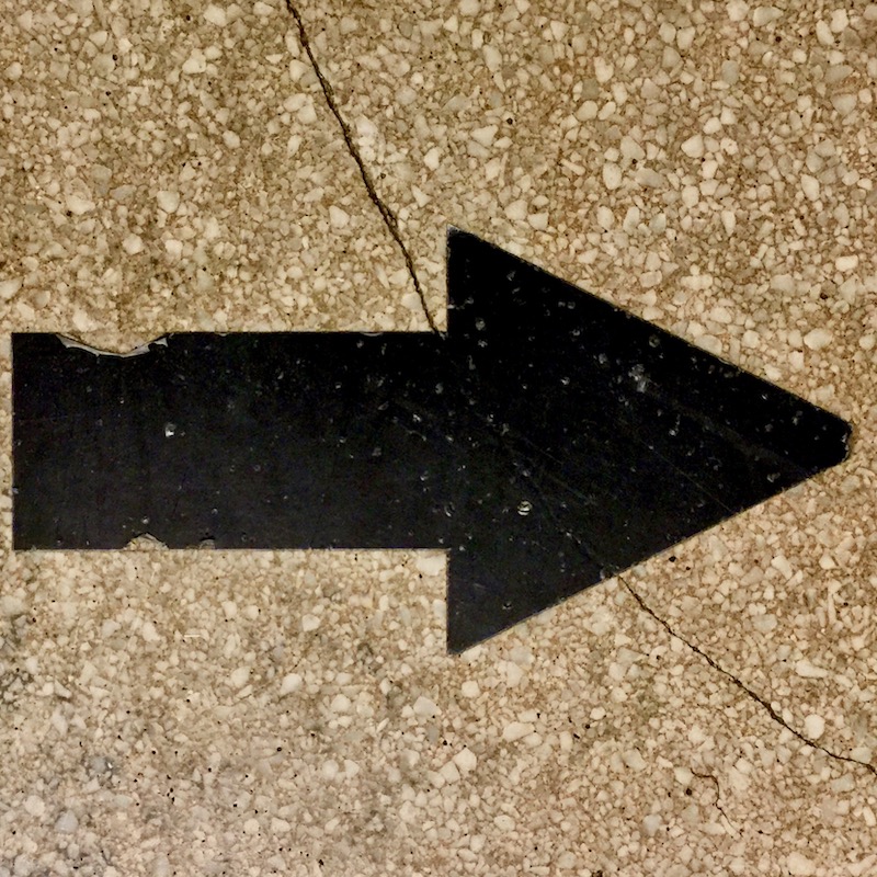 black arrow on cracked retail storefront