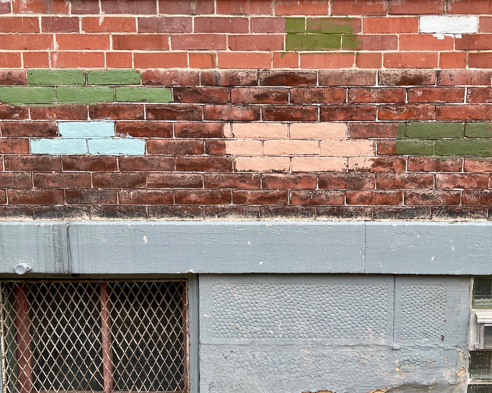 paint options applied to different sections of brick on exterior wall