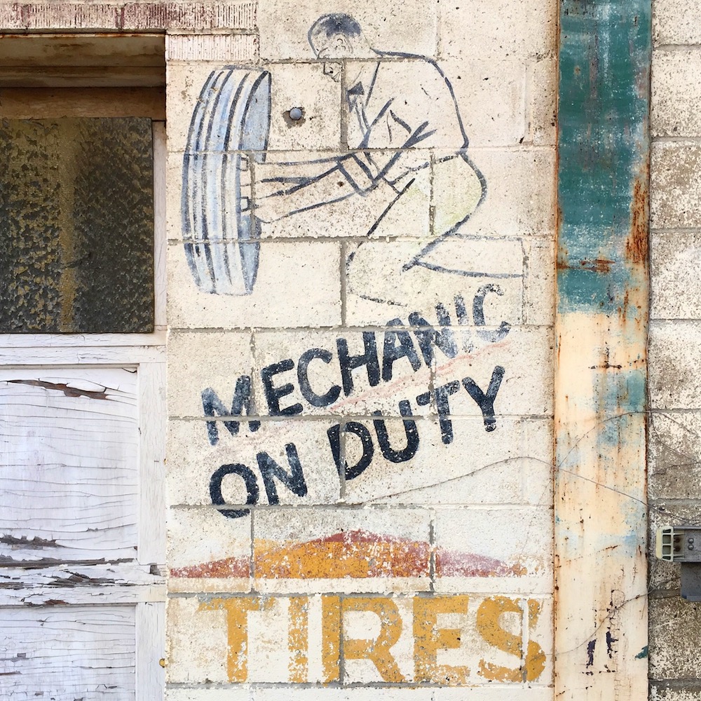 ghost sign of mechanic repairing flat tire