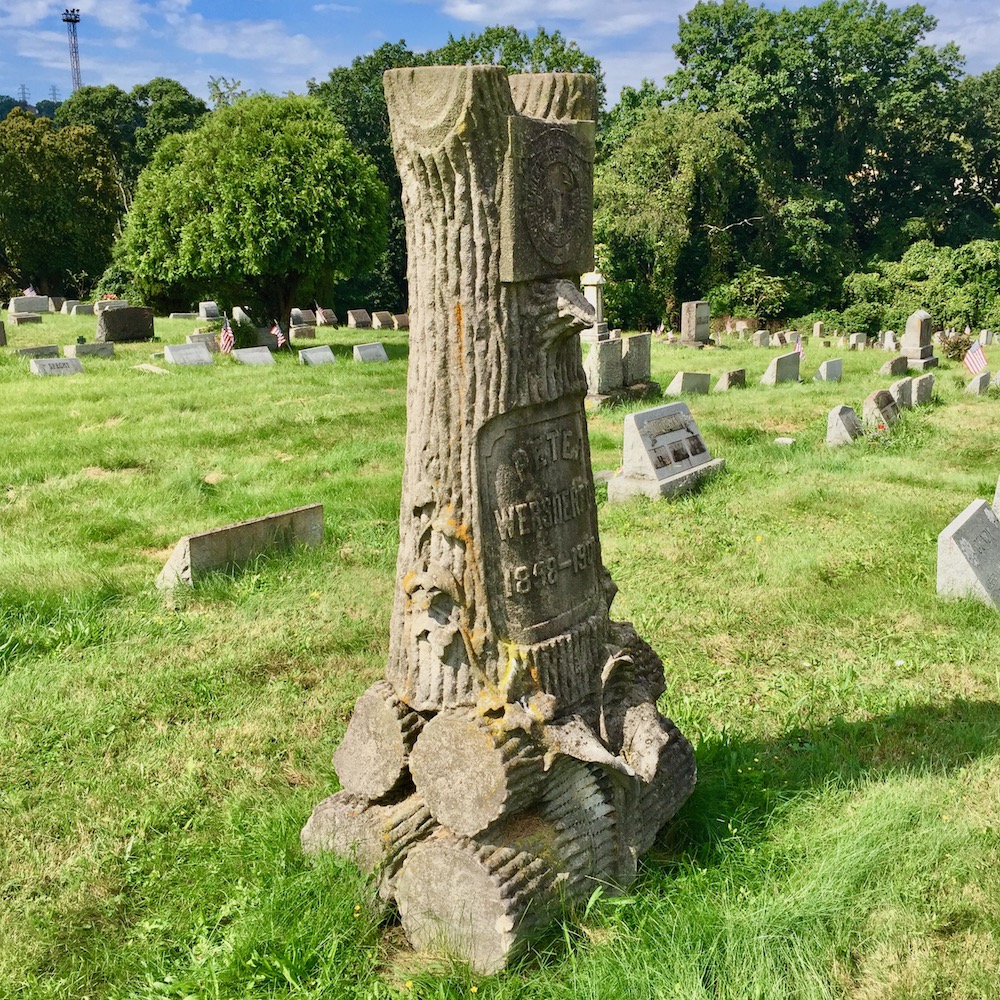Woodmen of the World grave monument carved to look like a tree trunk on a base of cut logs