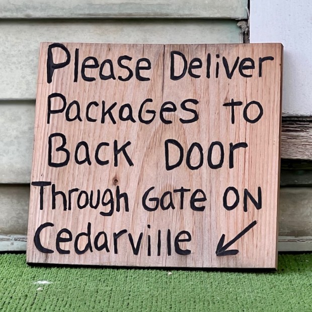 instructions for package delivery painted on wood scrap