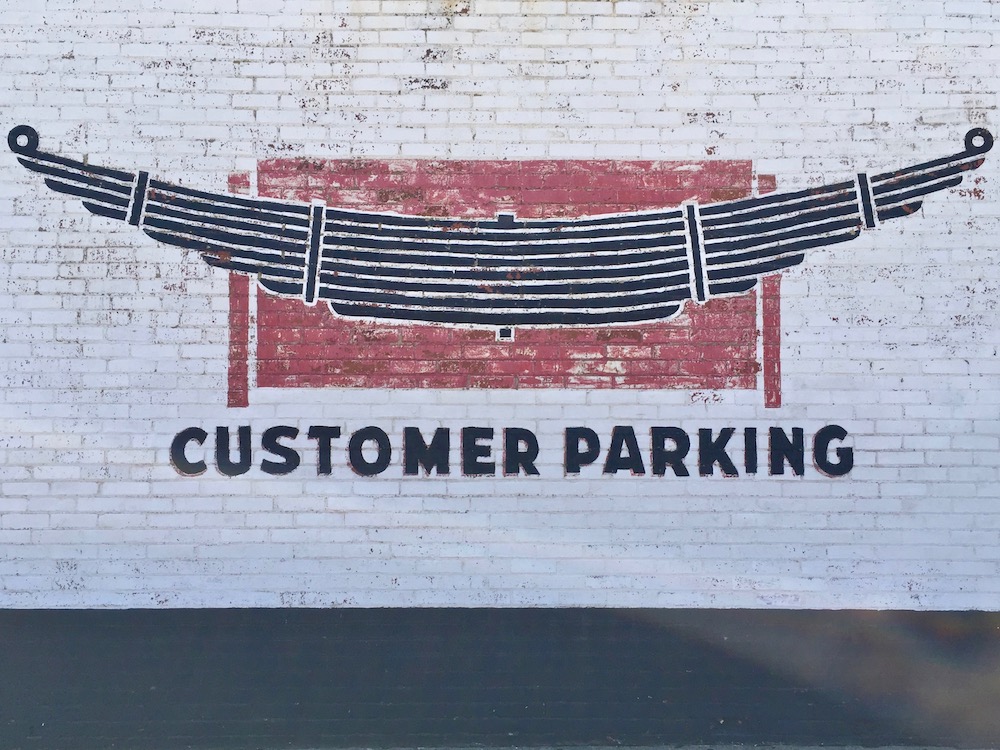 mural of automobile shock absorbers on brick wall of garage