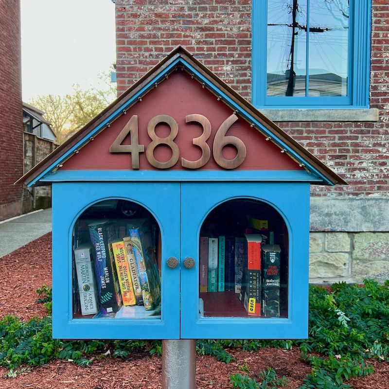 little free library in front of small apartment building