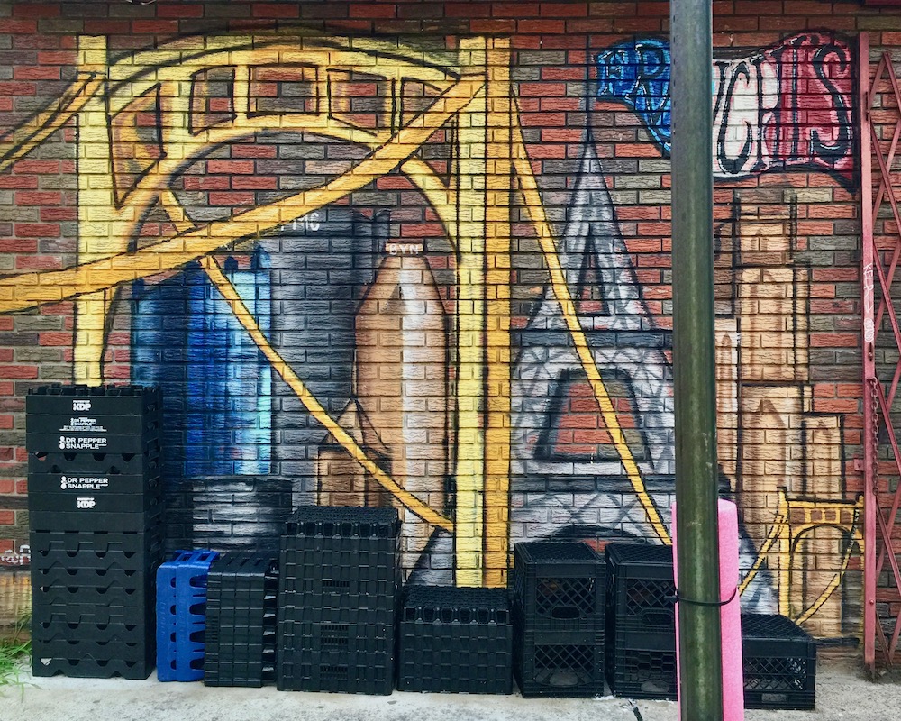 mural on brick wall with downtown Pittsburgh skyline and the Eiffel Tower