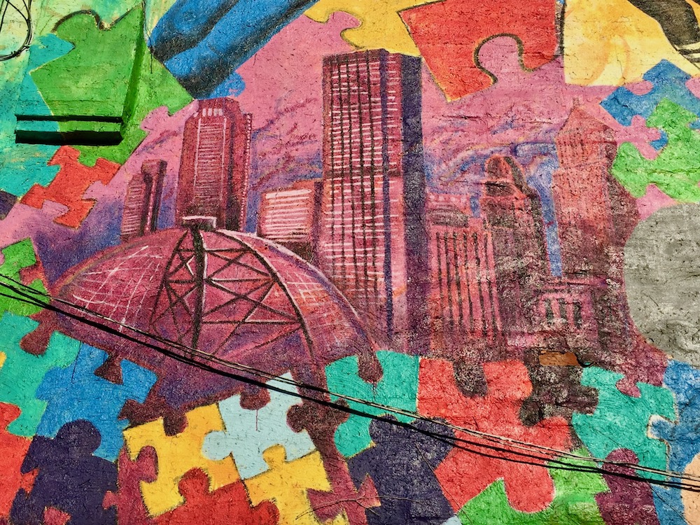 detail from mural featuring downtown Pittsburgh with jigsaw puzzle pieces