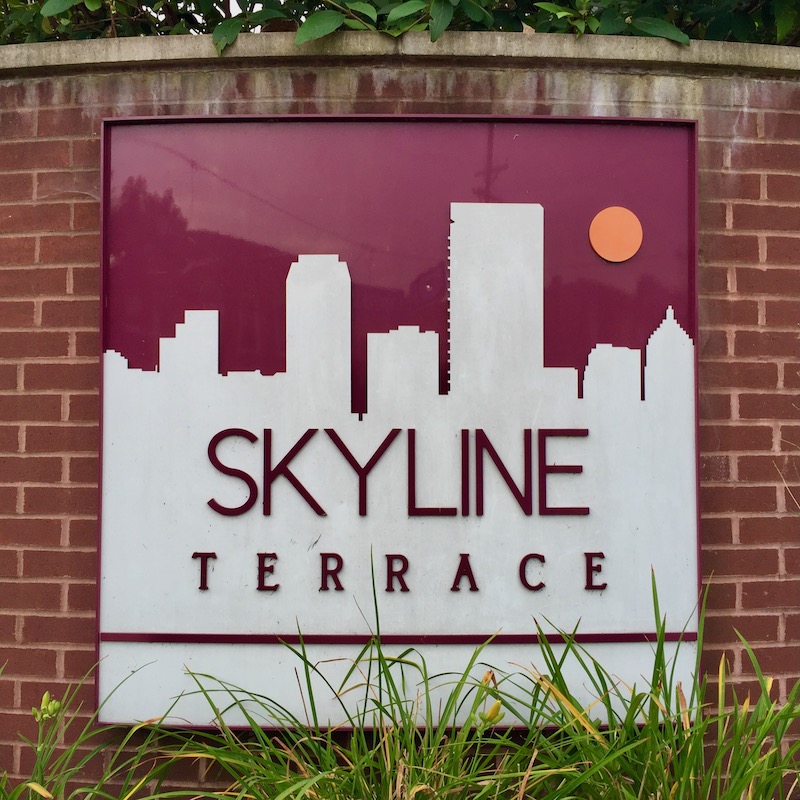 sign for apartment building including Pittsburgh skyline