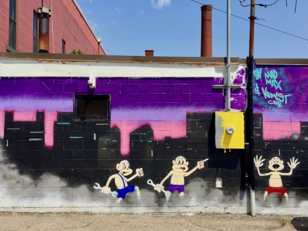 Mural of downtown Pittsburgh with monkeys holding wrenches