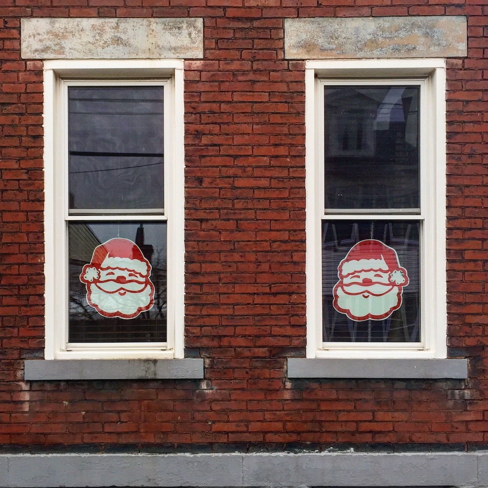 pair of windows, each with a large Santa head