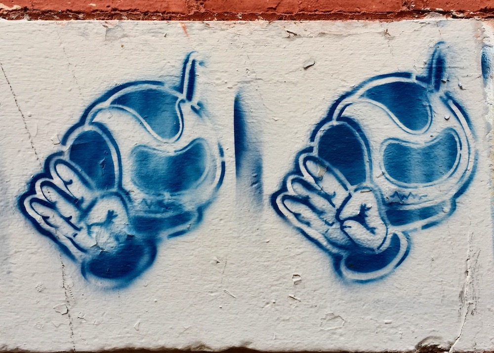 repeated stencil of astronaut making "OK" hand sign