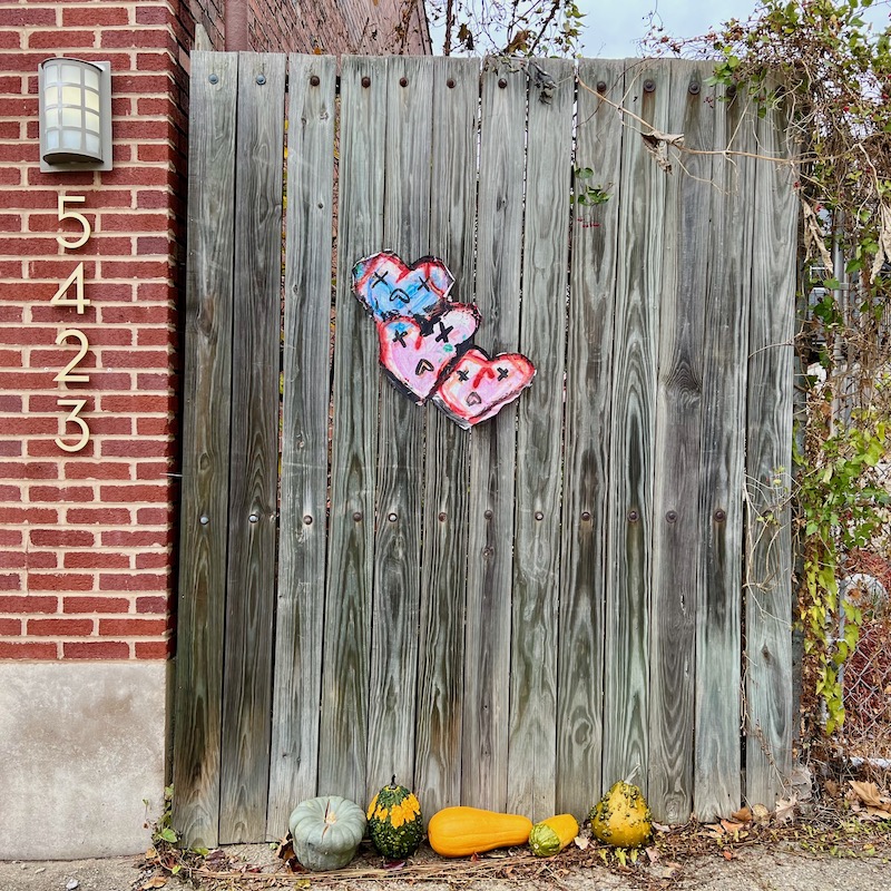 wheatpaste street art of heart-shaped face with Xs over eyes