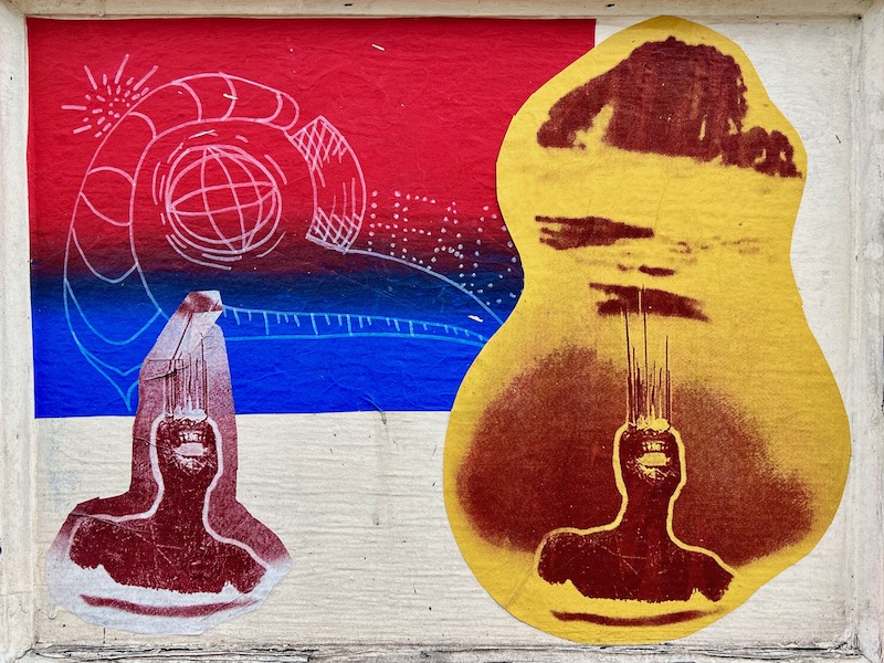 colorful collage of printed paper images layered on plywood covering vacant storefront