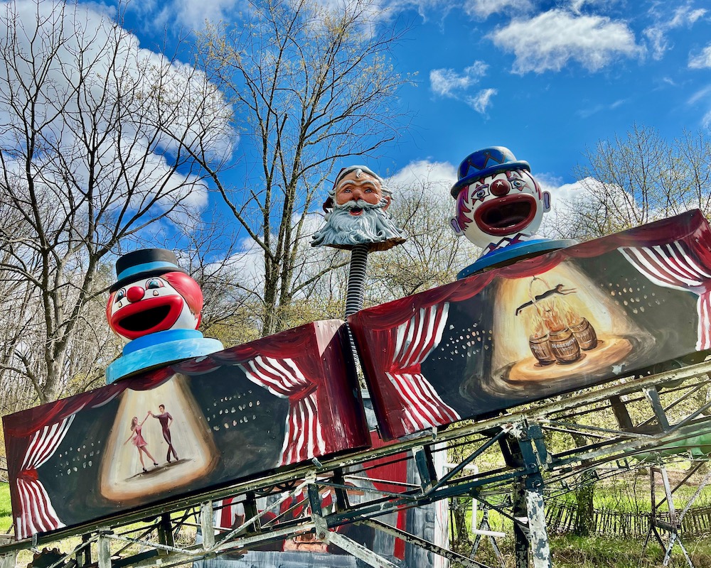 section of painted roller coaster cars with clown heads on them