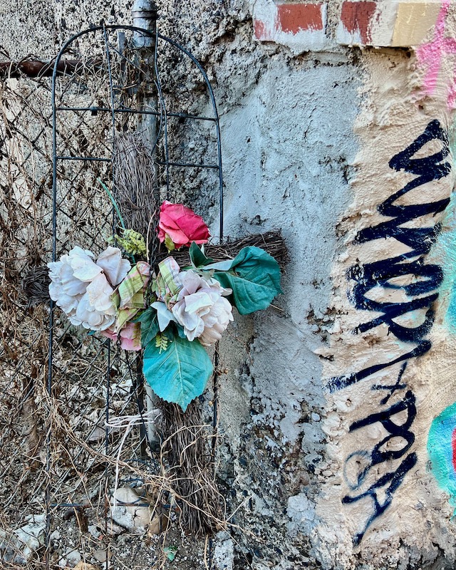 memorial cross left by alley fence