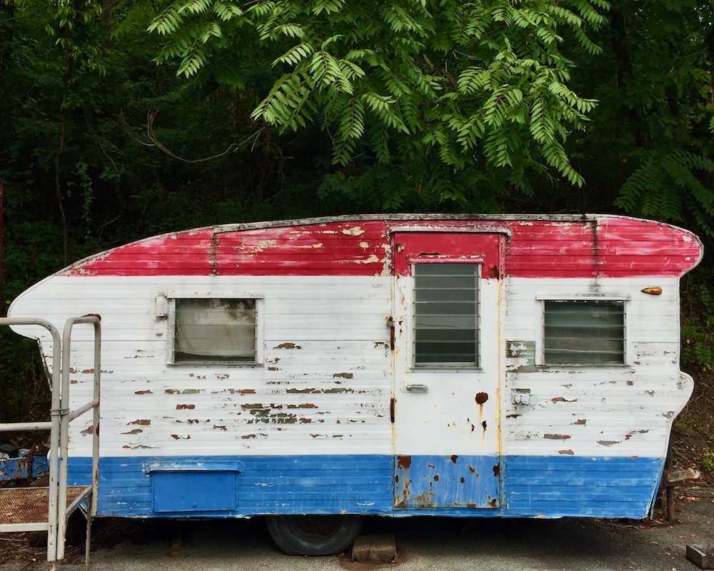 older camper trailer painted in red, white, and blue