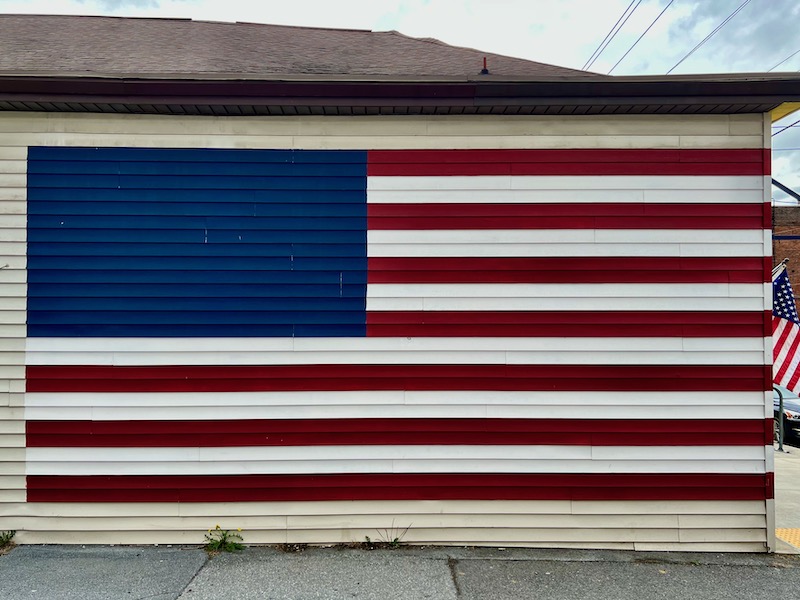 building siding painted like the American flag, but with no stars in the blue field