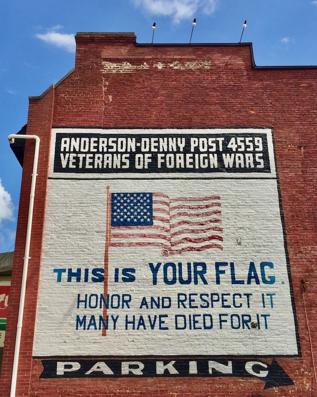 brick wall painted with mural of American flag