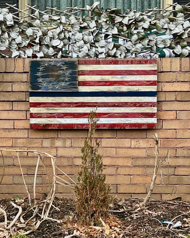 homemade wooden American flag on front porch of house