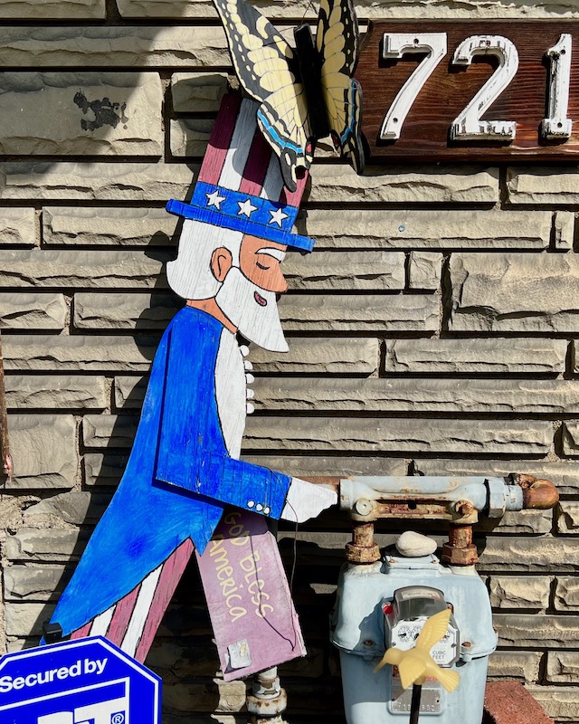 wooden painted cutout of Uncle Sam in front of house