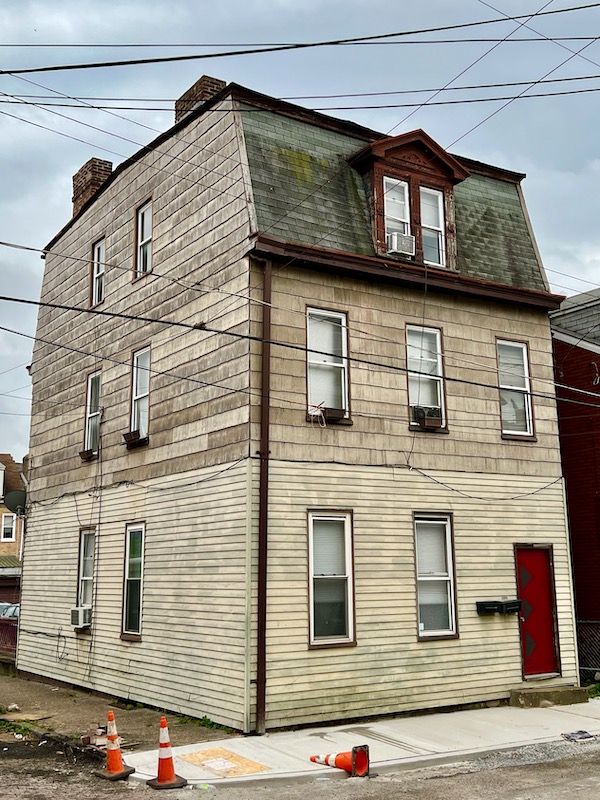 large older row house with multiple types of siding