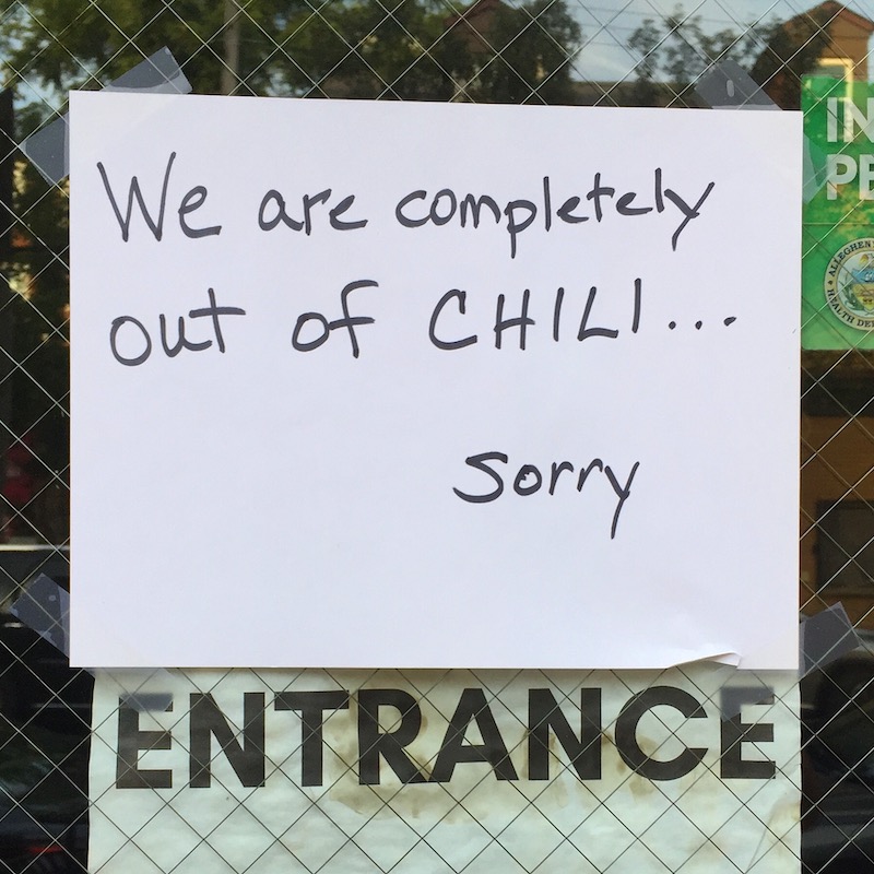 handwritten sign in hot dog shop window reading "We are completely out of chili ... sorry."