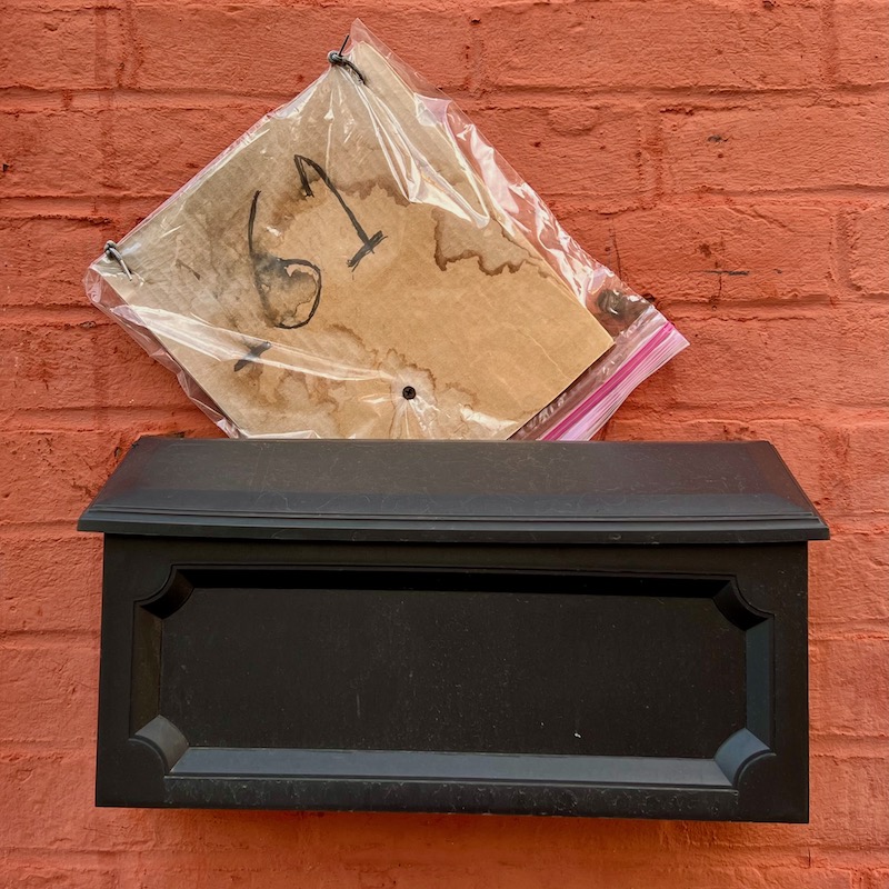home address written on cardboard, stuck inside Ziploc bag, and stuffed behind mailbox