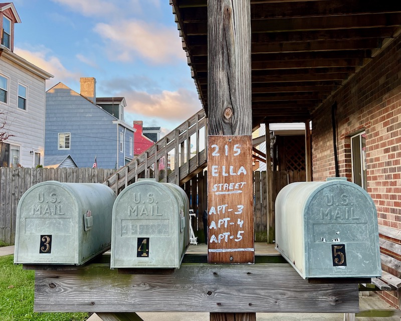 three mailboxes with hand-painted sign for the addresses