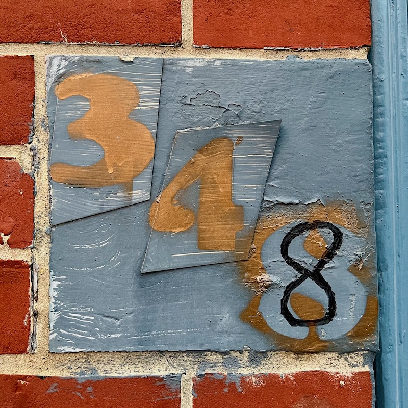 home address marker created from stickers and stenciled spray paint