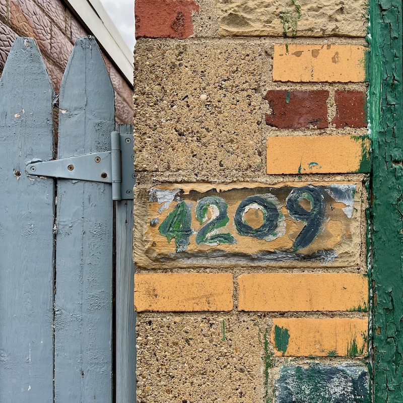 hand-painted address on masonry wall