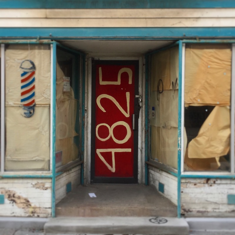 former barber shop with address painted on front door