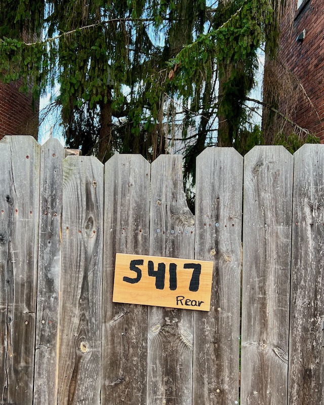 wooden gate with handmade address sign