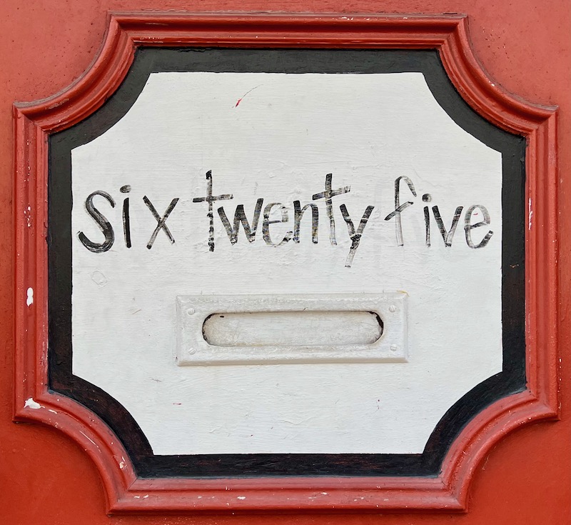 exterior door with handwritten address above mail slot