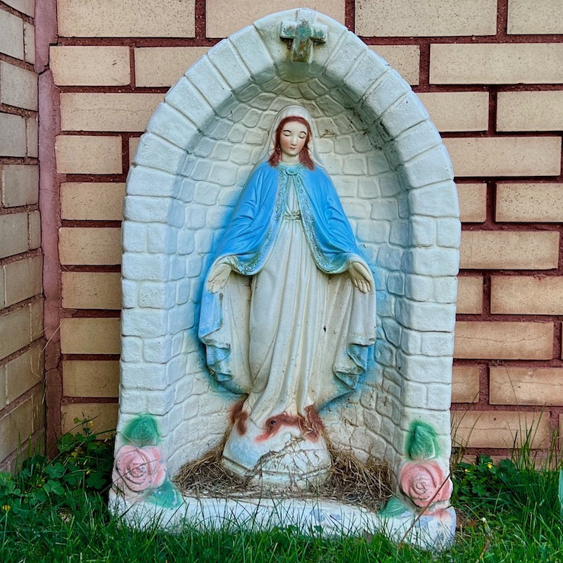 statue of Mary in front of house