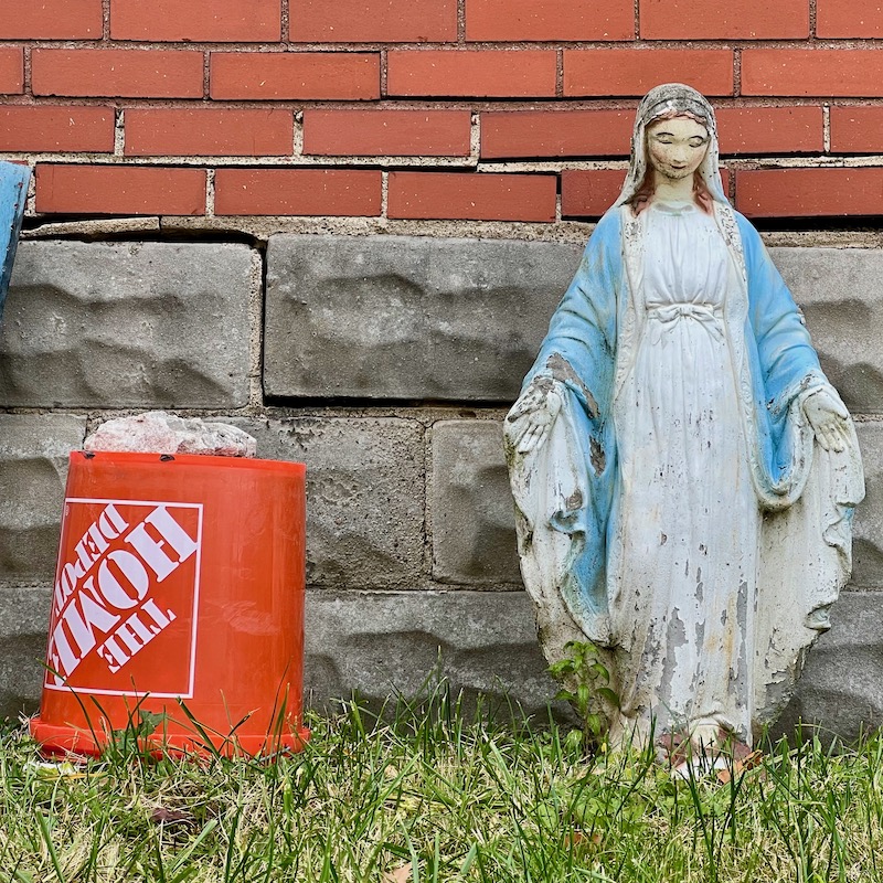 statue of Mary in front of older house