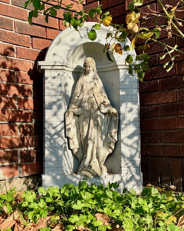 statue of Mary in front of house
