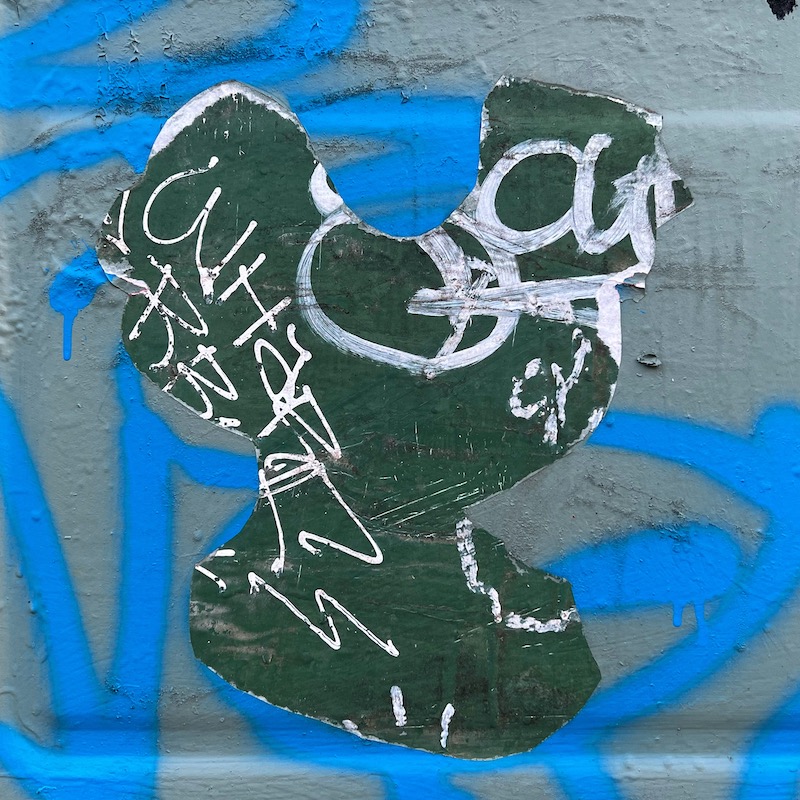 negative image of rooster removed from wheat paste street art