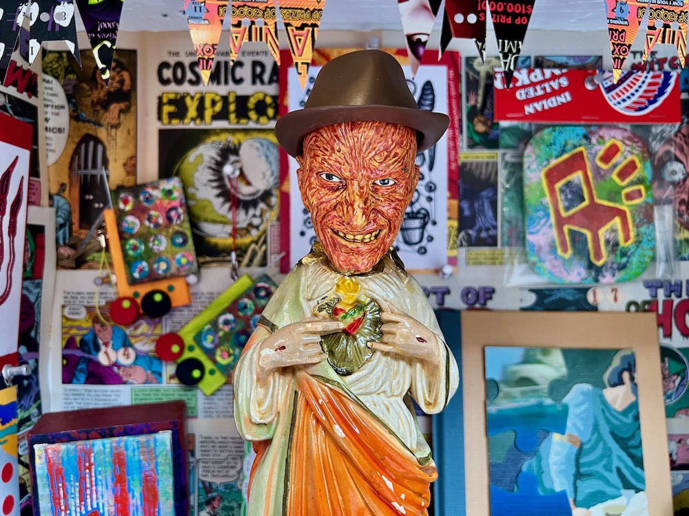 art installation including comic books, paintings, sculptural collage