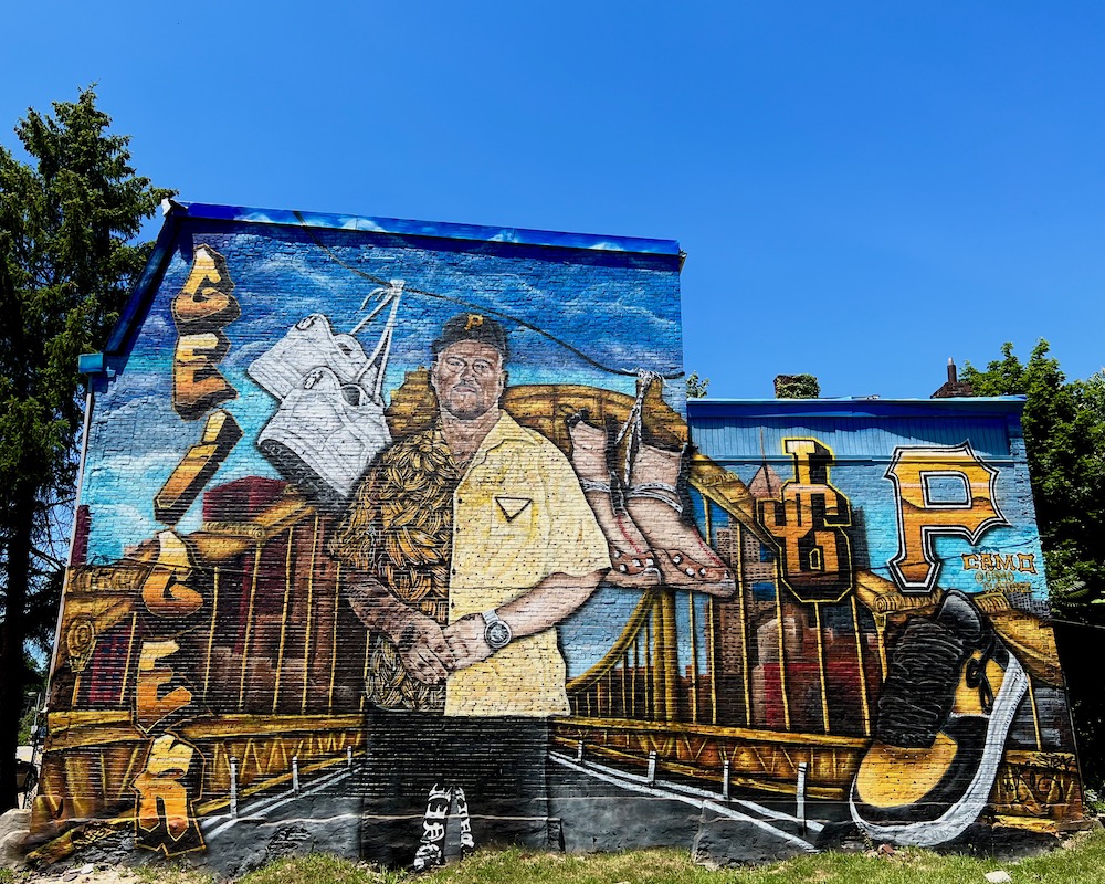 mural on side of row house featuring shoe designer and downtown Pittsburgh