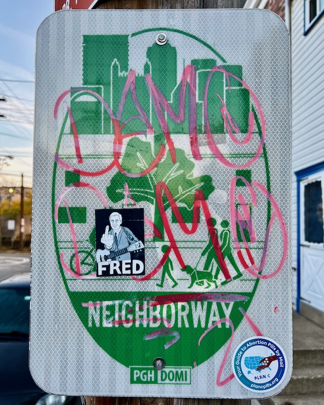 sign for Pittsburgh neighborway with skyline of downtown Pittsburgh