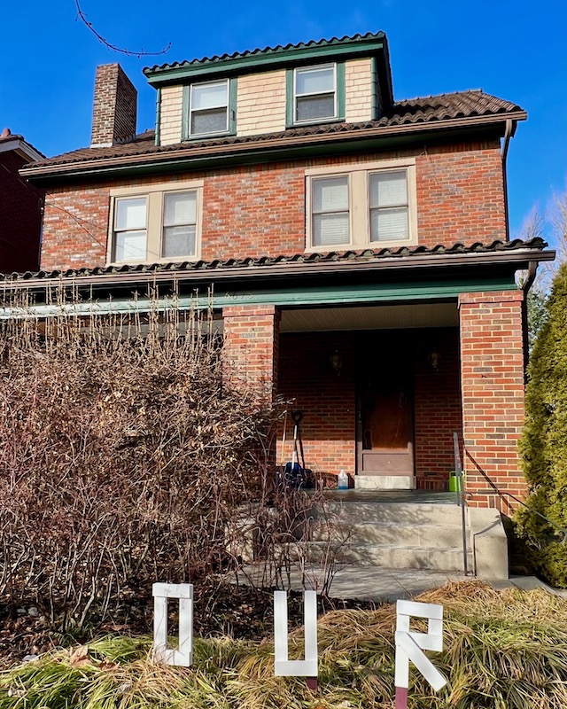 handmade letters attached to residential house reading "our"