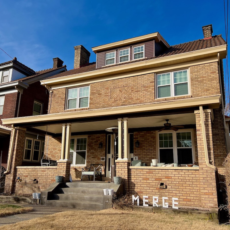handmade letters attached to residential house reading "merge"