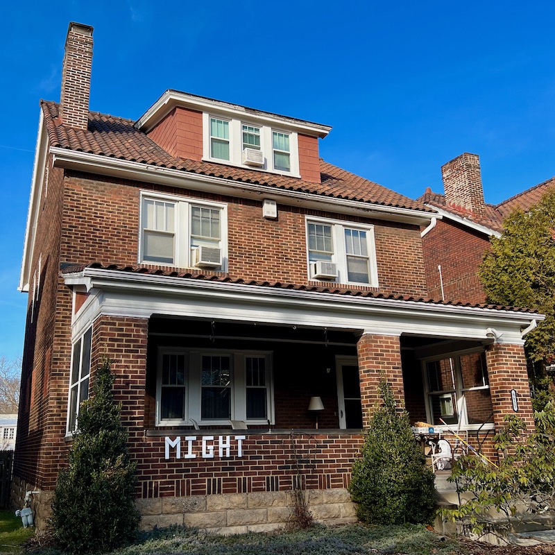 handmade letters attached to residential house reading "might"