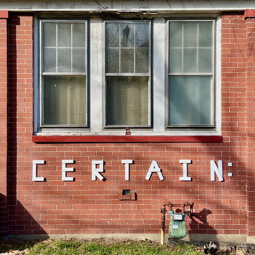 handmade letters attached to residential house reading "certain"