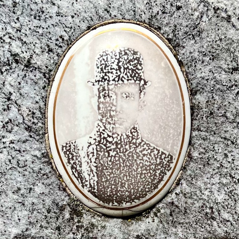 faded ceramic photograph inset into grave stone